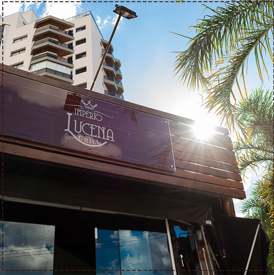 Letreiro do Império Lucena Grill na fachada, com sol entre as palmeiras